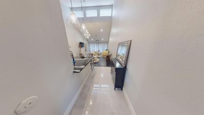 Entry way from the front door of Condo. Featuring vaulted ceilings impressive lighting and opening up to the open concept living and dining area. | Image 2