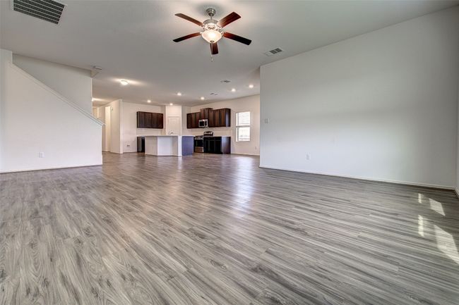 Unfurnished living room with ceiling fan, wood finished floors, recessed lighting, and baseboards | Image 5