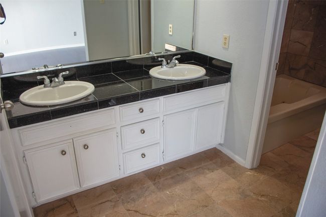 Primary bathroom featuring double vanity and tub / shower combination with marble flooring | Image 23