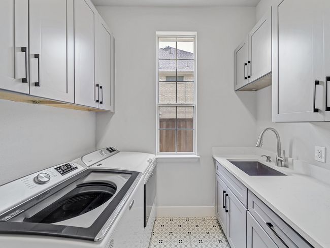 Washroom featuring separate washer and dryer, cabinet space, and baseboards | Image 29