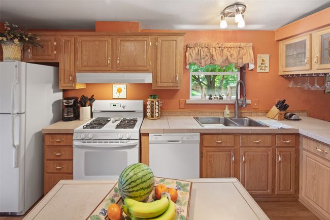 Kitchen featuring white appliances, extractor fan, and light countertops | Image 16