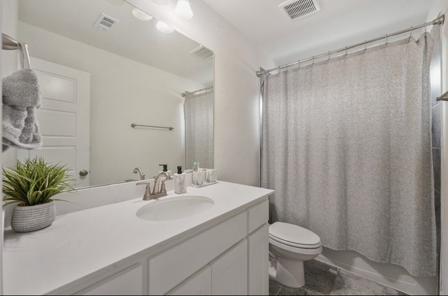 Full bath featuring vanity, tile patterned flooring, toilet, and shower / tub combo | Image 19