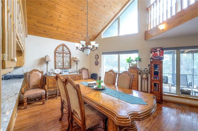 Dining area featuring high vaulted ceiling, healthy amount of natural light, light wood-type flooring, a chandelier, and wood ceiling | Image 9