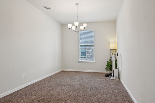 Spare room featuring a chandelier, carpet flooring, and baseboards | Image 34