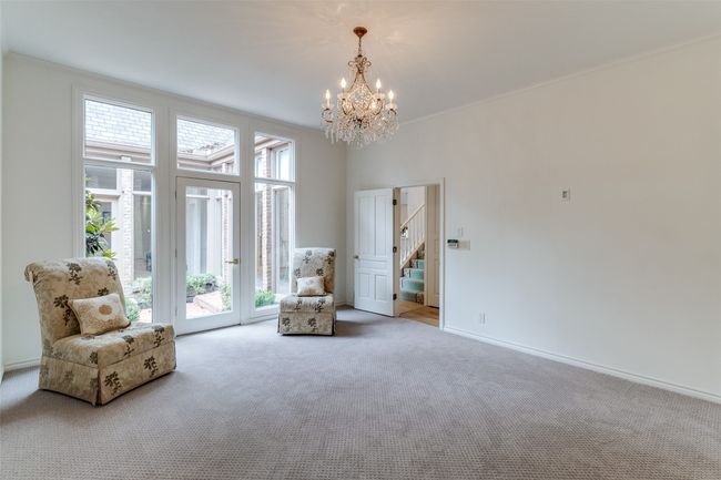 Living area featuring carpet flooring, a chandelier, stairway, and baseboards | Image 15