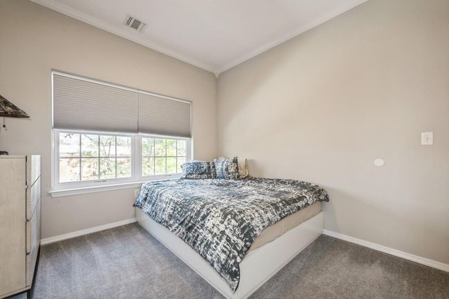 Carpeted bedroom featuring baseboards, crown molding, and visible vents | Image 10
