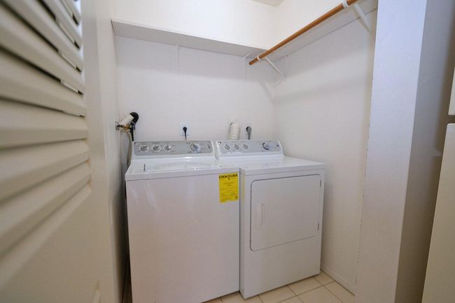 Washroom with washing machine and clothes dryer, laundry area, and light tile patterned flooring | Image 9