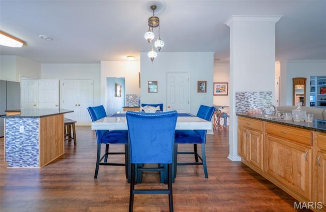 Dining room featuring dark wood-style flooring and ornamental molding | Image 11