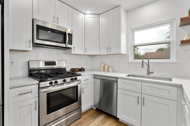 Kitchen featuring appliances with stainless steel finishes, light countertops, and white cabinetry | Image 8