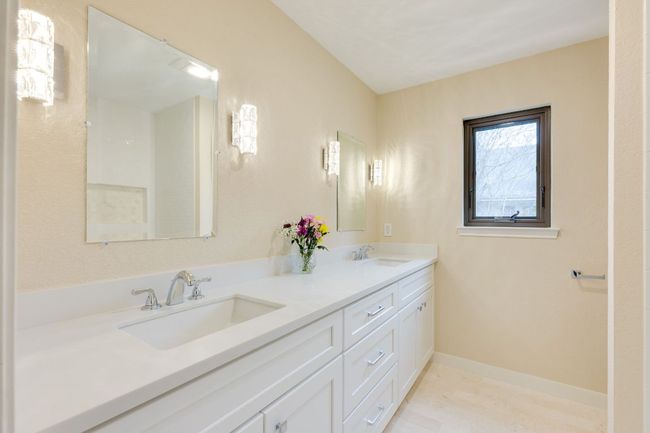 Full secondary bathroom updated with modern double vanity & beautiful lighting | Image 22