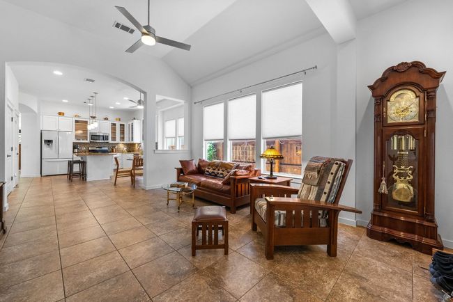 Living area with baseboards, visible vents, lofted ceiling, arched walkways, and ceiling fan | Image 15