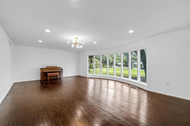 Unfurnished living room featuring wood-type flooring, recessed lighting, a chandelier, and baseboards | Image 5