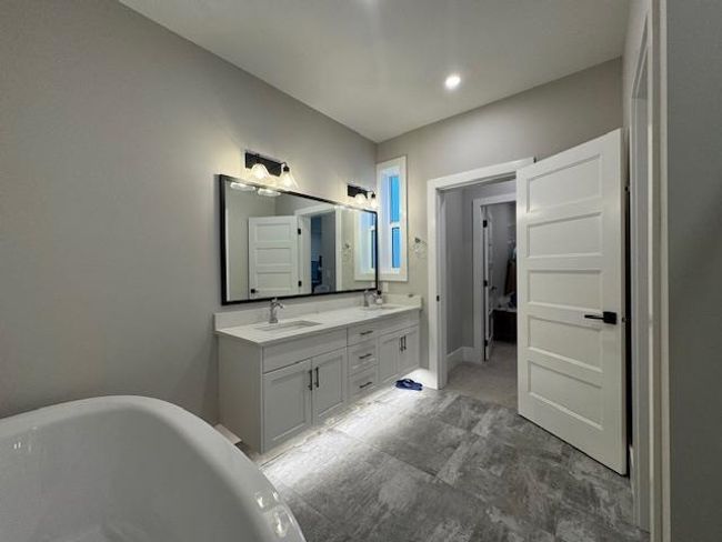 Full bathroom featuring a soaking tub, a sink, and double vanity | Image 27