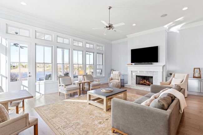 Living room with light wood-style flooring, a premium fireplace, ceiling fan, ornamental molding, and recessed lighting | Image 5