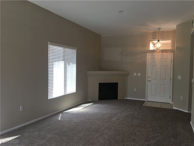 Unfurnished living room featuring carpet, a fireplace, and baseboards | Image 11