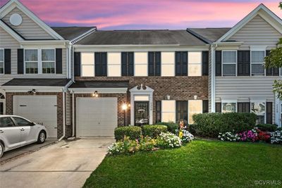 Townhome / multi-family property with a garage and a lawn | Image 1