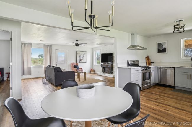 Dining space featuring a chandelier, dark wood-style flooring, and baseboards | Image 18