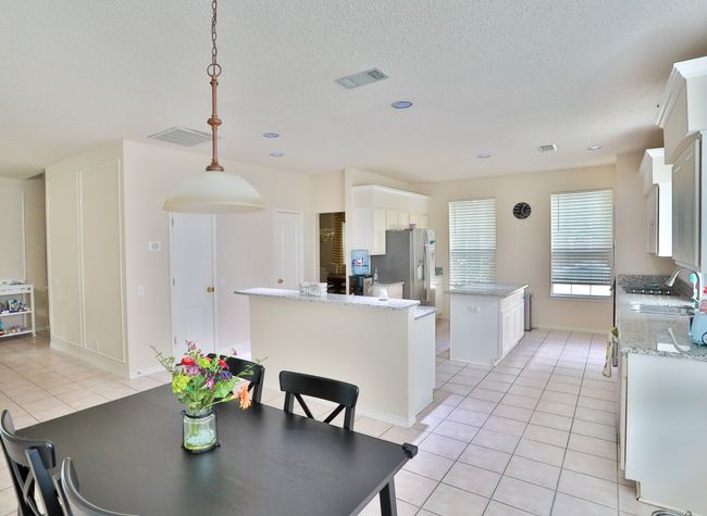 Dining area featuring light tile patterned floors, a textured ceiling, and recessed lighting | Image 8