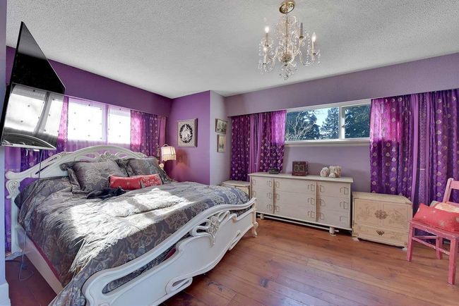 Bedroom featuring multiple windows, a textured ceiling, a chandelier, and hardwood / wood-style floors | Image 33