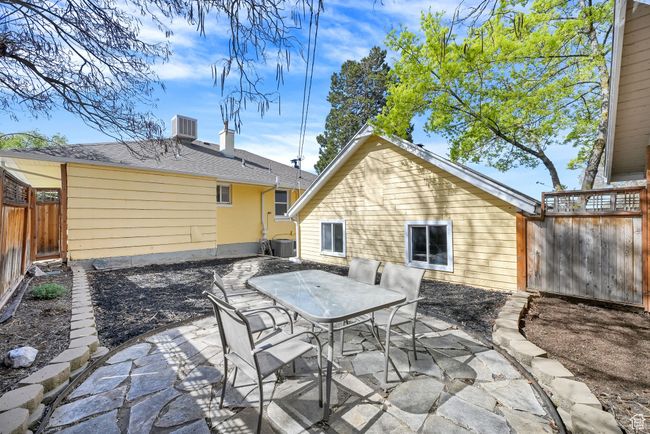 Back of house with cooling unit, a fenced backyard, a patio, and outdoor dining area | Image 27