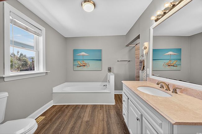 Full bath featuring wood finished floors, a garden tub, and vanity | Image 12
