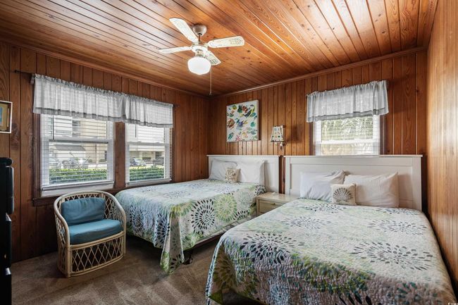 Bedroom with wooden ceiling, carpet floors, wooden walls, and ceiling fan | Image 12