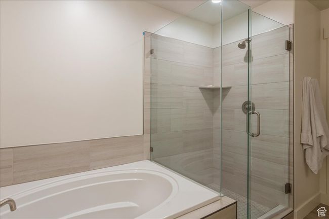 Bathroom featuring a stall shower and a bath | Image 18