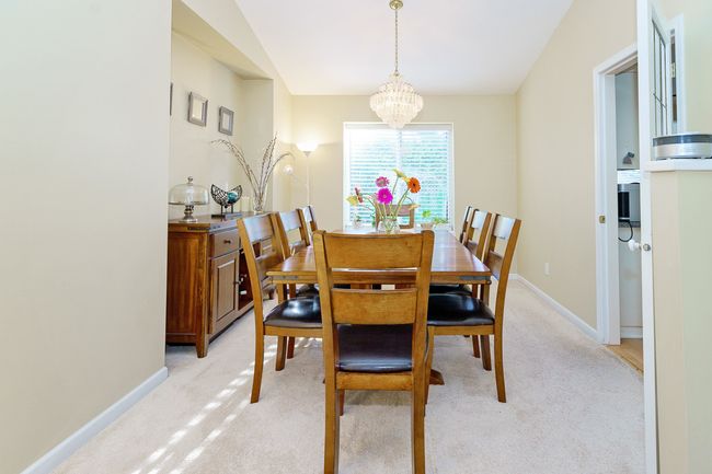 Dining space with a chandelier, light carpet, and baseboards | Image 6