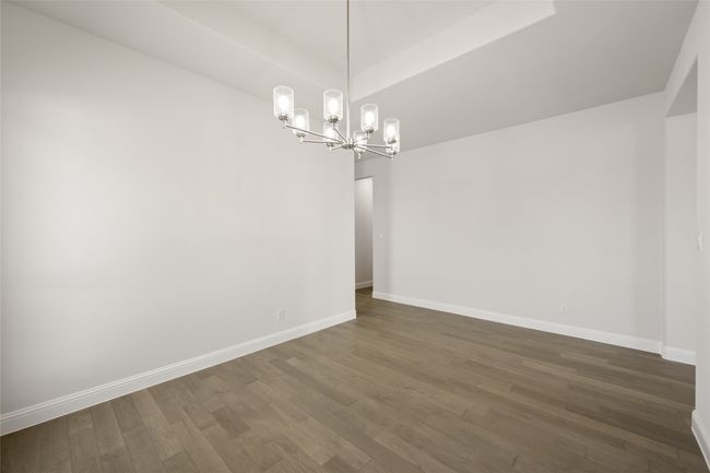 Empty room featuring a chandelier, dark wood-type flooring, and baseboards | Image 13