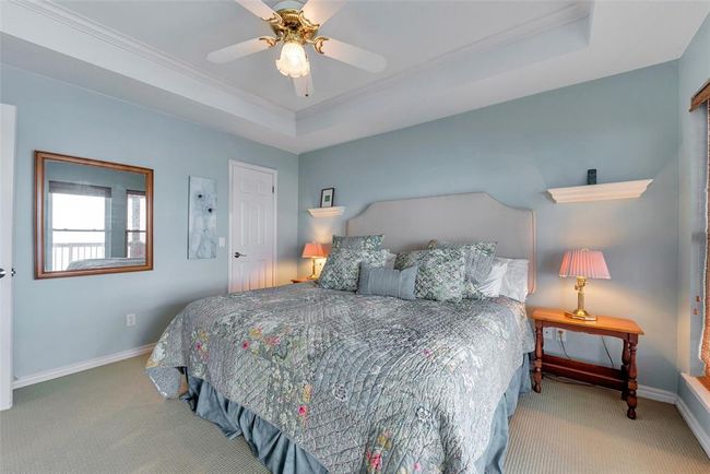 This carpeted primary suite features a ceiling fan for added comfort and a tranquil palette that enhances the restful vibe. | Image 23