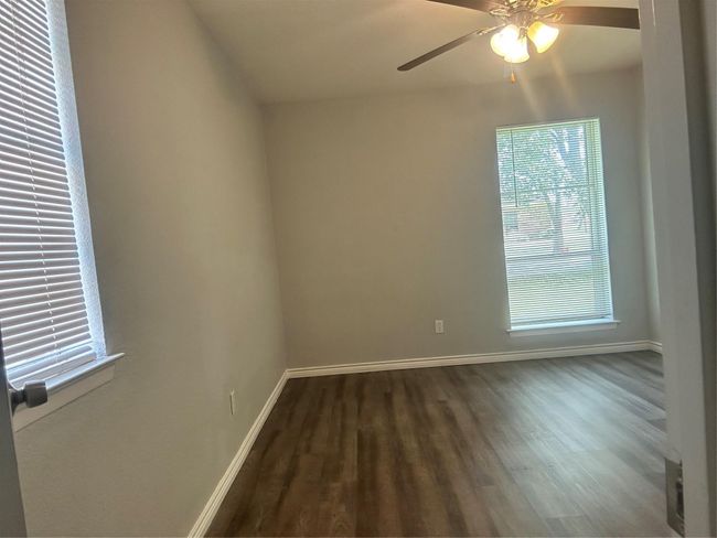 Spare room with wood finished floors, baseboards, and a ceiling fan | Image 10