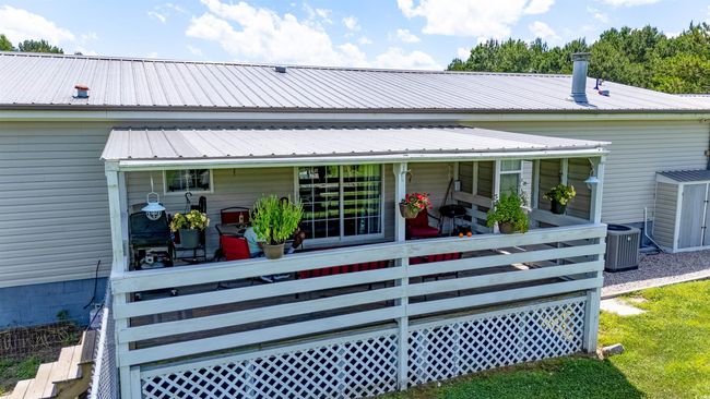 Rear view of house with a metal roof and a sunroom | Image 15