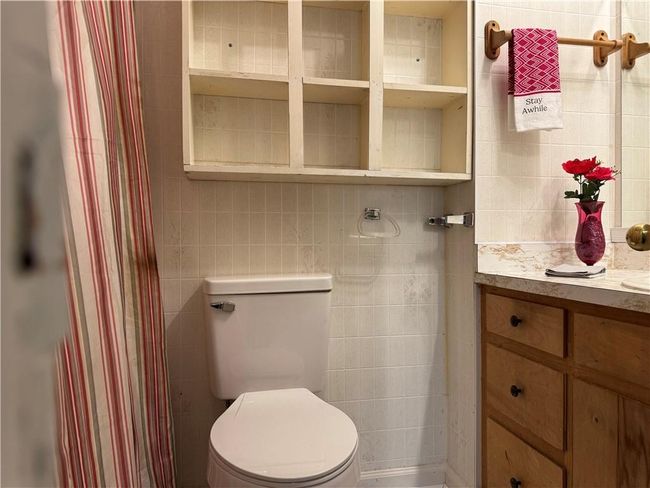 Bathroom featuring tile walls, vanity, a shower with curtain, and decorative backsplash | Image 10