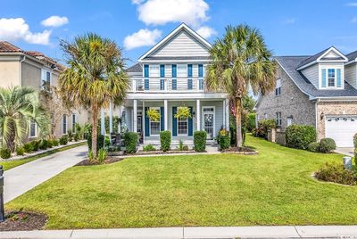 View of front of home featuring a front lawn, a porch, and a garage | Image 1