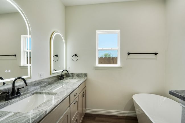 Bathroom with a freestanding tub, baseboards, a sink, and double vanity | Image 17