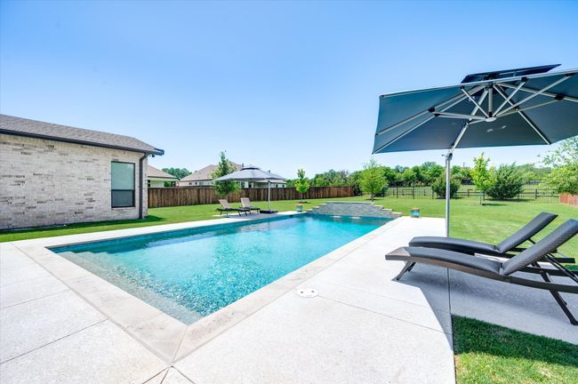 View of pool featuring a patio area, a lawn, a fenced backyard, and a fenced in pool | Image 32