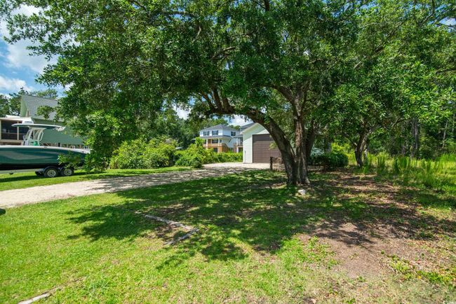 View of green lawn featuring a garage and driveway | Image 29
