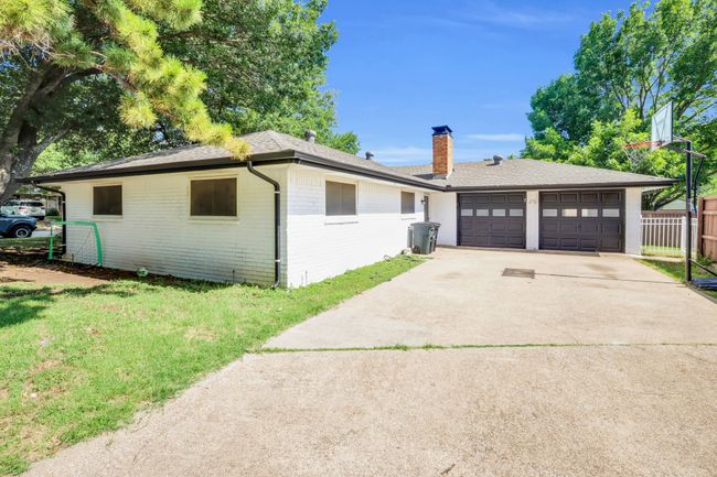 View of front of property featuring brick siding, driveway, a garage, a shingled roof, and a chimney | Image 5