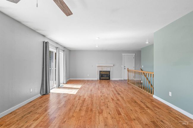 Unfurnished living room featuring light wood-style floors, a ceiling fan, and a tile fireplace | Image 10