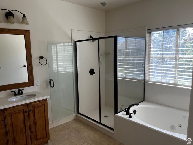 Full bathroom featuring a stall shower, a tub with jets, vanity, and tile patterned flooring | Image 17