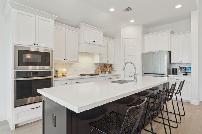 Kitchen with oven, a sink, freestanding refrigerator, built in microwave, and decorative backsplash | Image 8