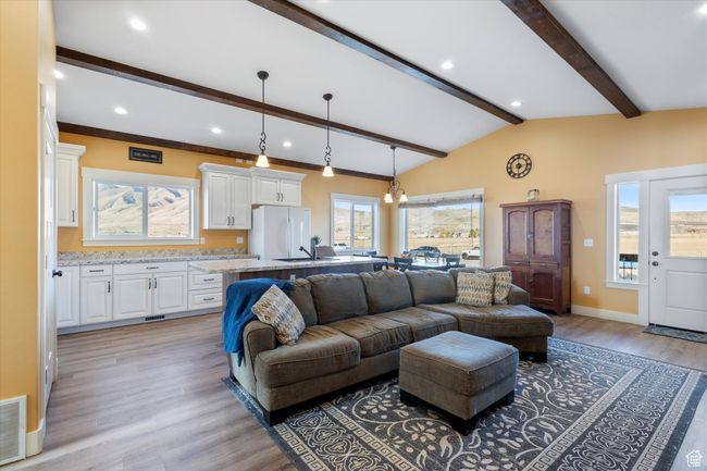 Living room with visible vents, baseboards, lofted ceiling with beams, recessed lighting, and light wood-style floors | Image 12