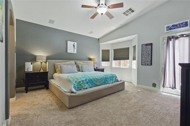 Carpeted bedroom with high vaulted ceiling, ceiling fan, baseboards, and visible vents | Image 18