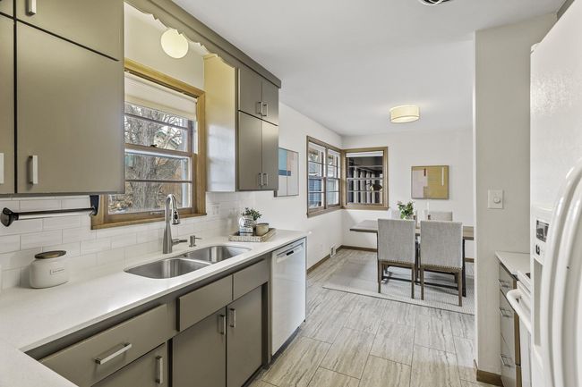 View of kitchen and dining area. The far window looks into the three season porch | Image 14