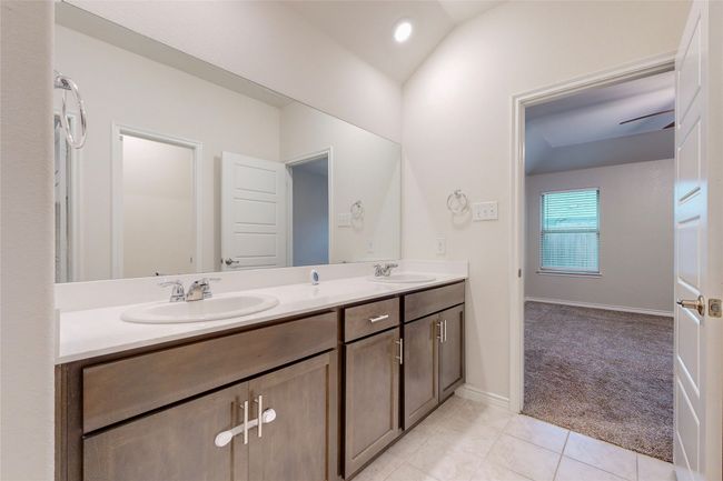 Full bath with baseboards, tile patterned flooring, double vanity, and a sink | Image 24