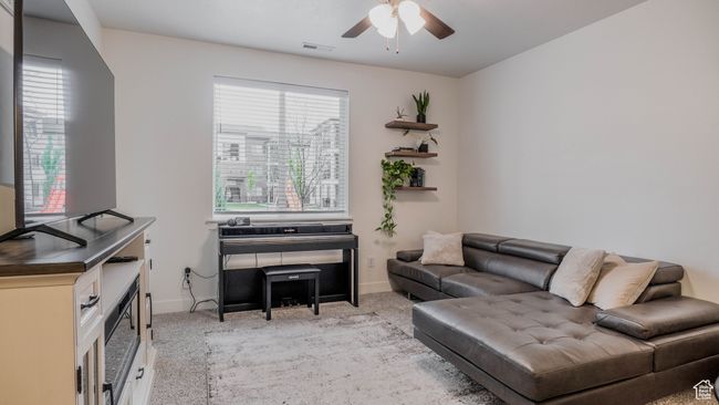 Interior space featuring light carpet, a ceiling fan, visible vents, and baseboards | Image 5