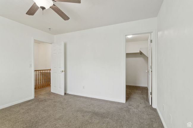 Empty room with carpet floors, ceiling fan, baseboards, and a pendent fire sprinkler | Image 14