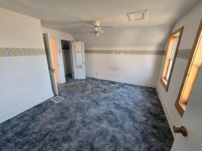 Spacious west bedroom has hardwood under carpeting | Image 25
