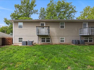 Rear view of property with a balcony, central AC, and a lawn | Image 2