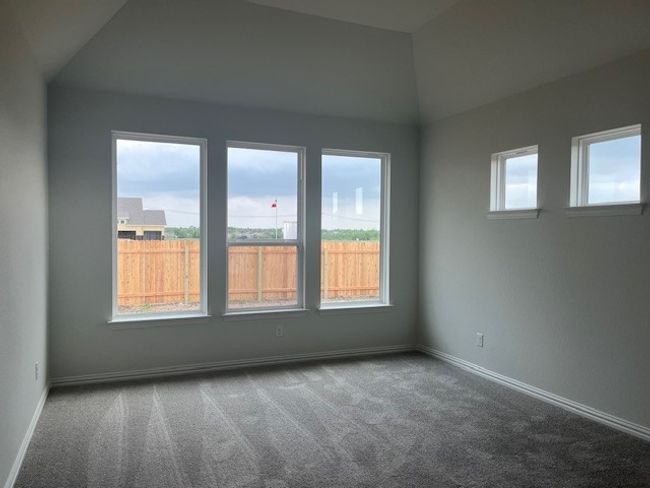 Carpeted spare room with a healthy amount of sunlight, baseboards, and vaulted ceiling | Image 6